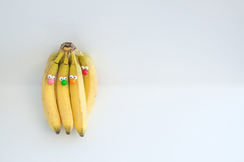 A bunch of bananas decorated with eyes and noses.