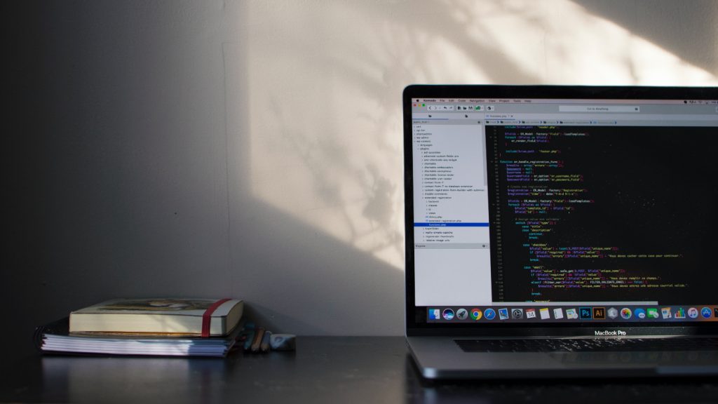 A laptop on a table with an opened code editor.