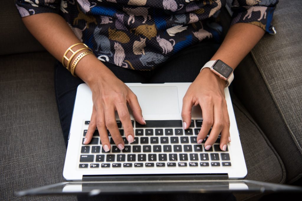 A woman typing on a laptop.