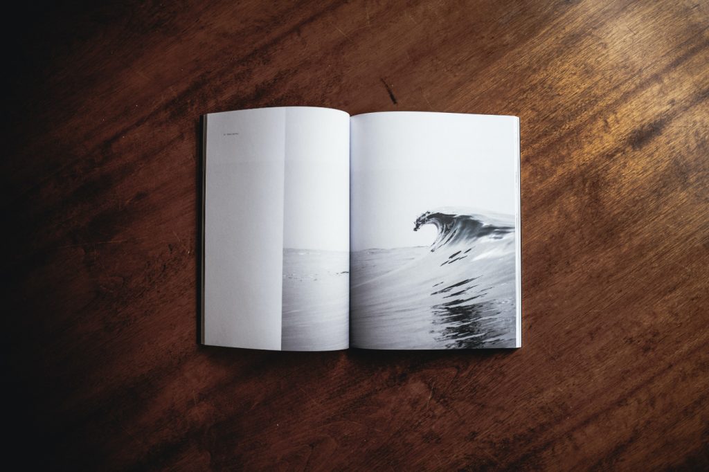 An opened book with a picture of a big wave.