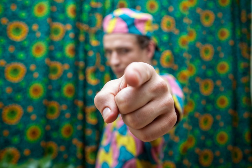A person pointing at the camera, at you.