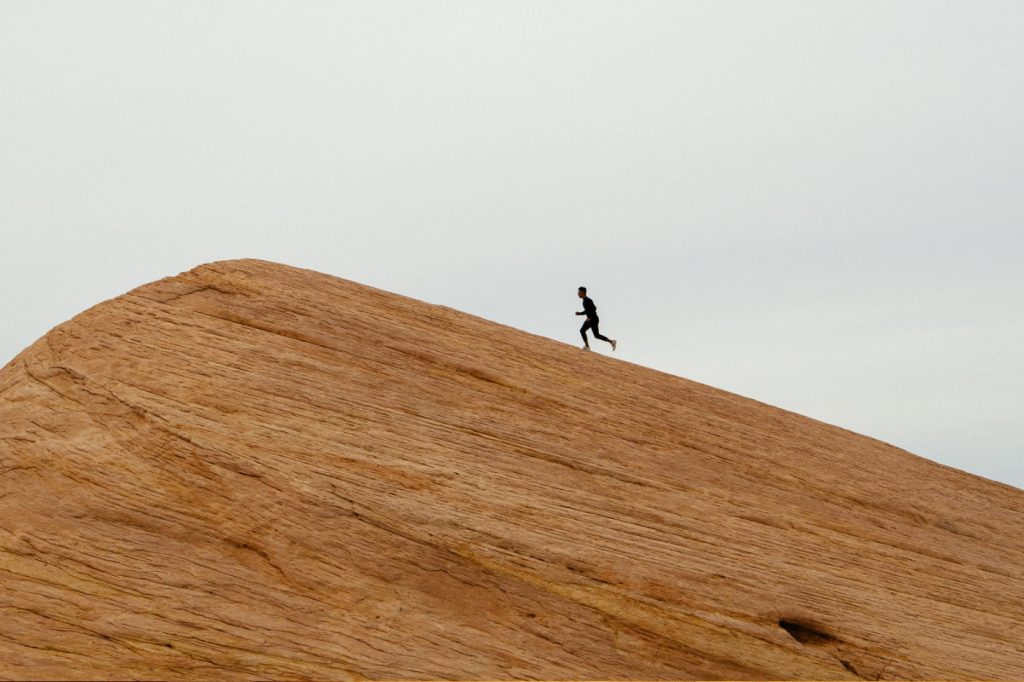 A person running to the top of a hill.