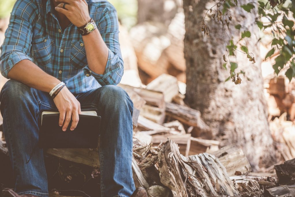 A person lost in thoughts holding a notebook.