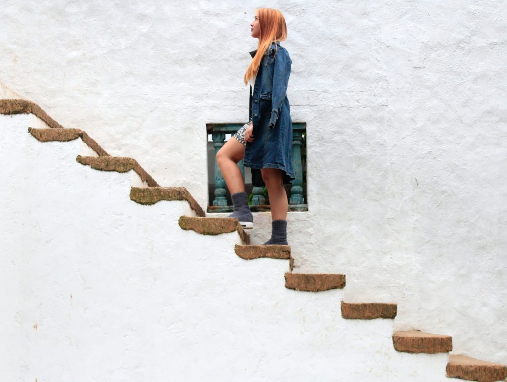 A woman climbing on stairs, looking up.