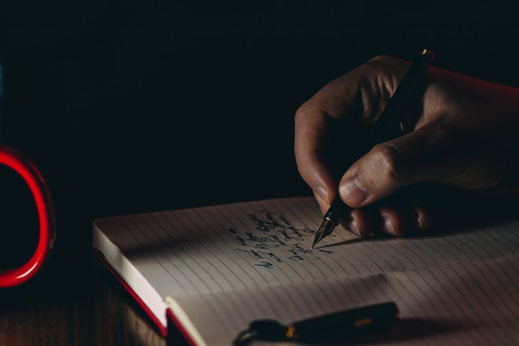 A person writing in a notebook.