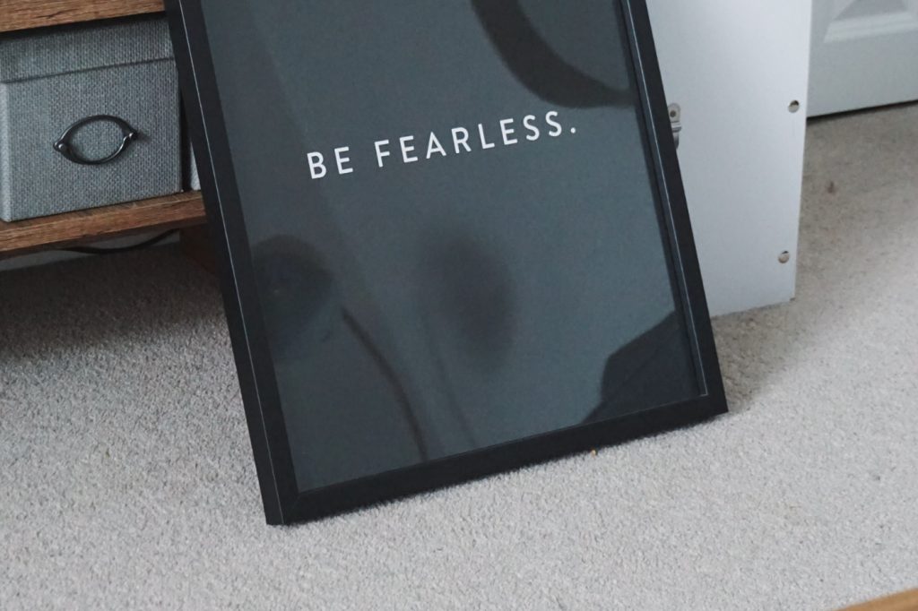 Text "be fearless" in a black photo frame.