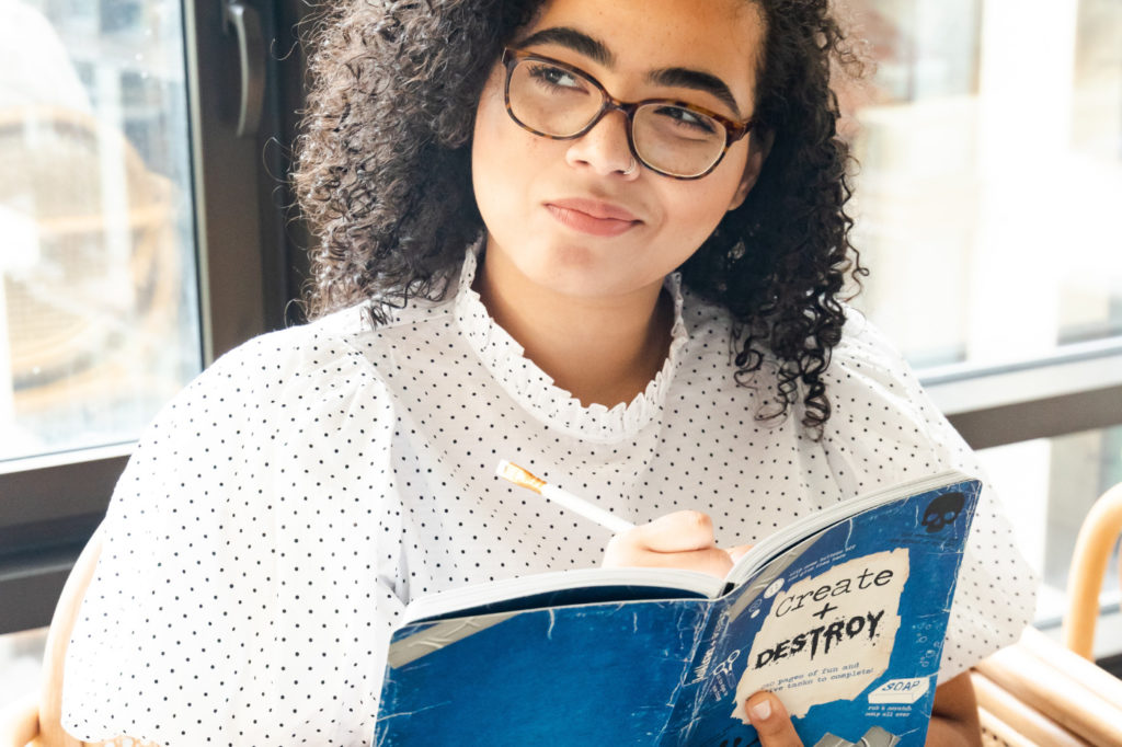 A person holding a book with a hopeful look on their face.