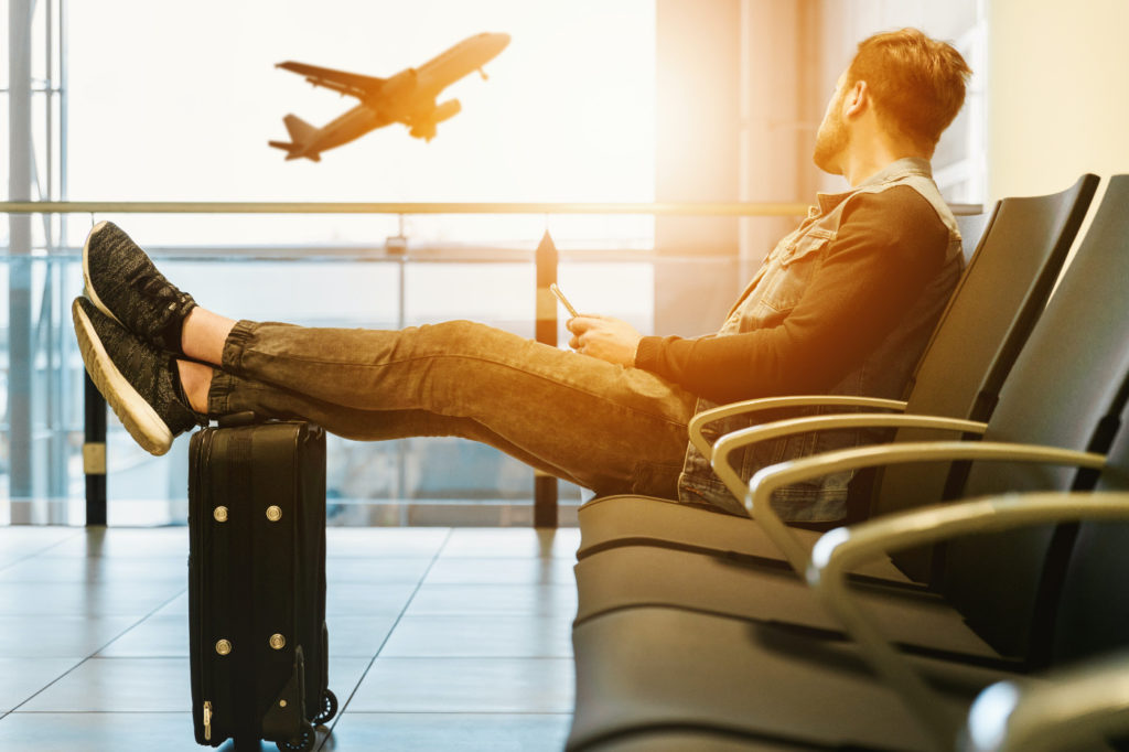 A person holding a smartphone while waiting at an airport.