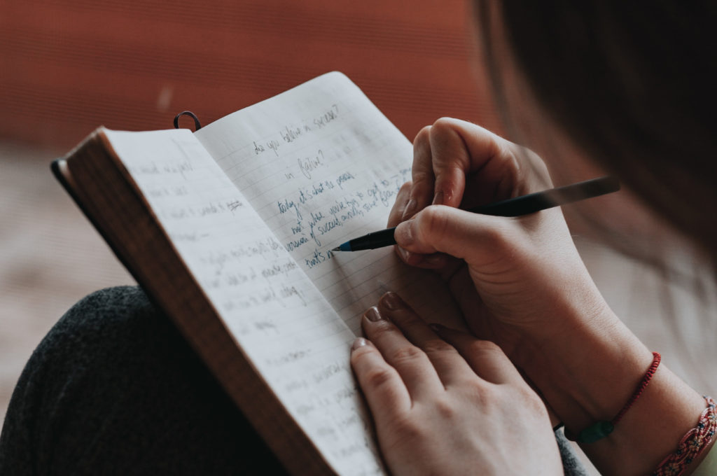 A person writing in a notebook.