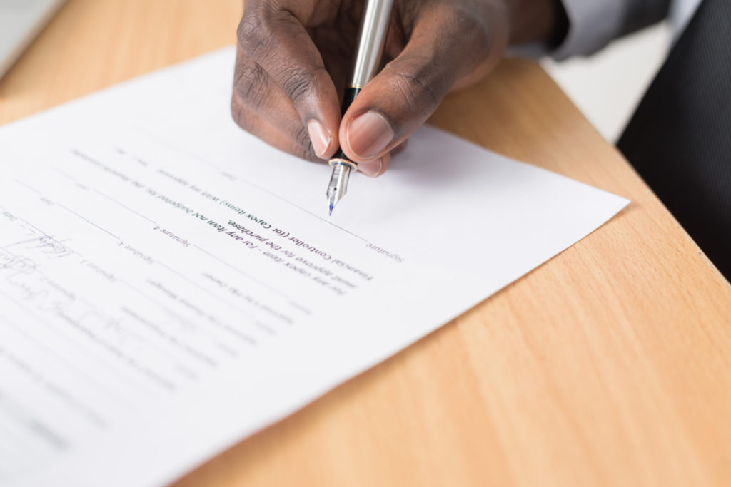 A person signing a contract.