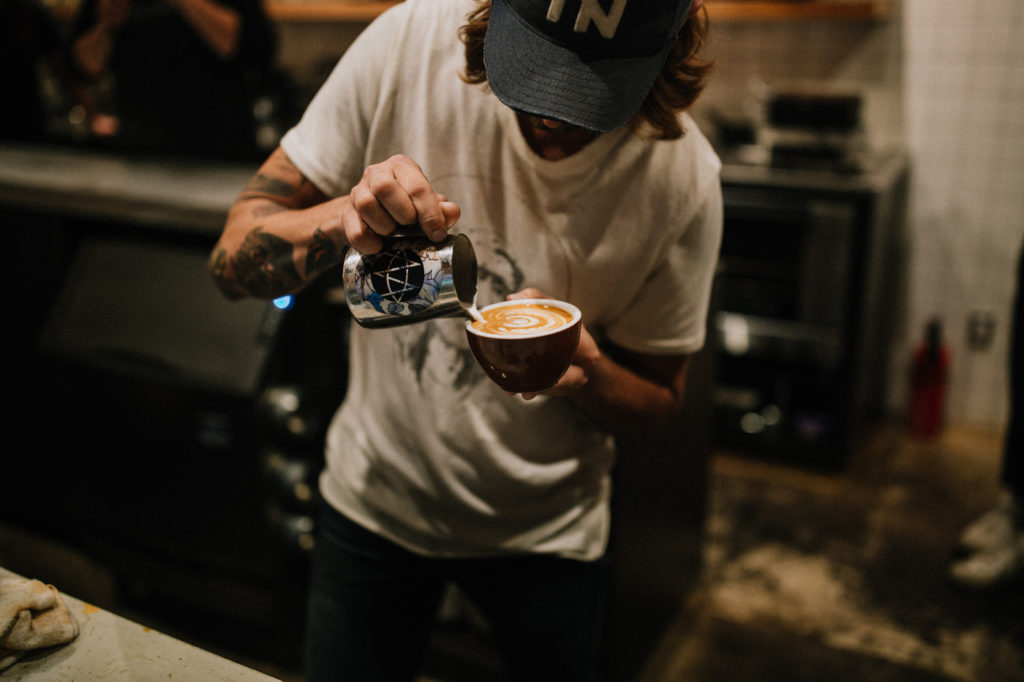 A barista carefully, meticulously preparing a coffee.