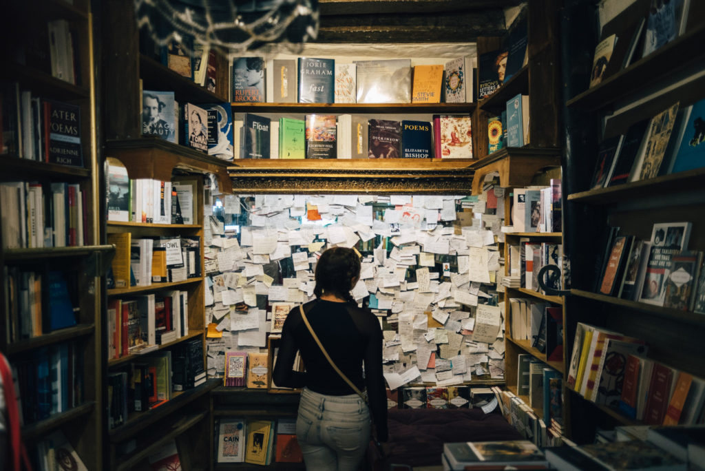 A woman standing in front of a wall full of sticky notes.