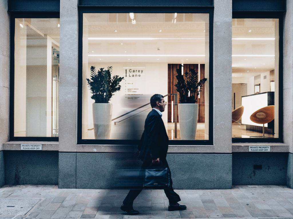 A person with a briefcase rushing on the street.