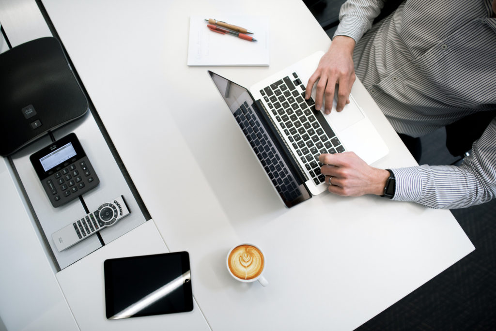 A person working on a laptop at a desk.