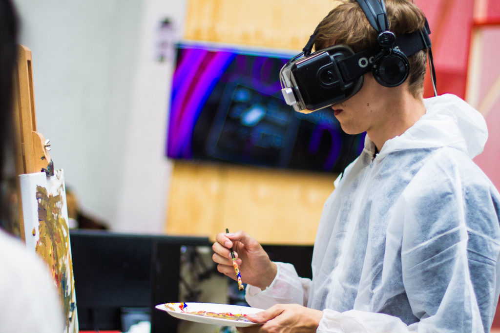 A person painting using a virtual reality headset.