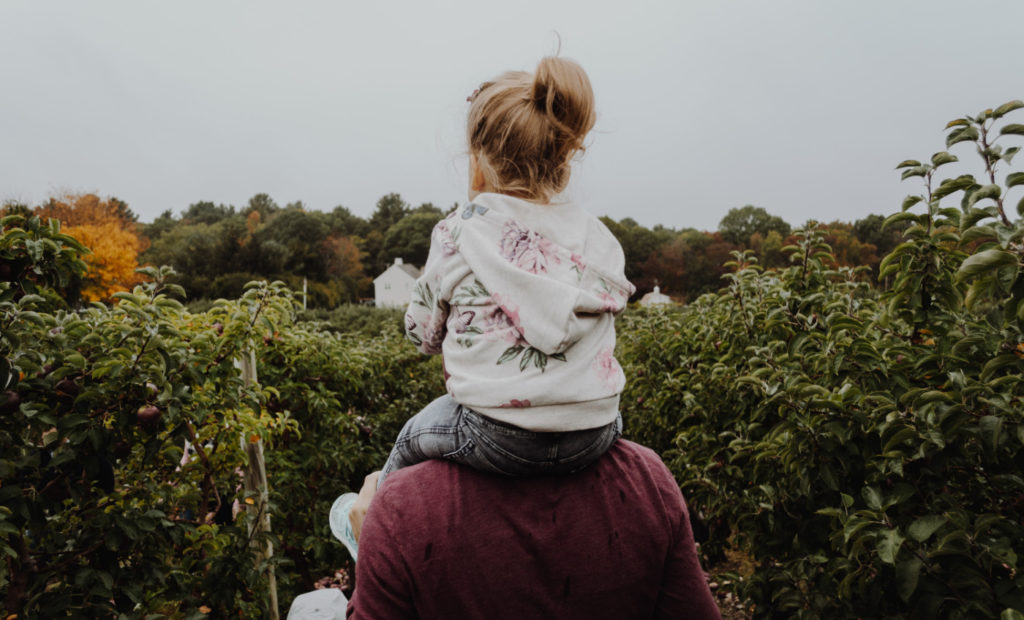 A person carrying a child on their shoulders.