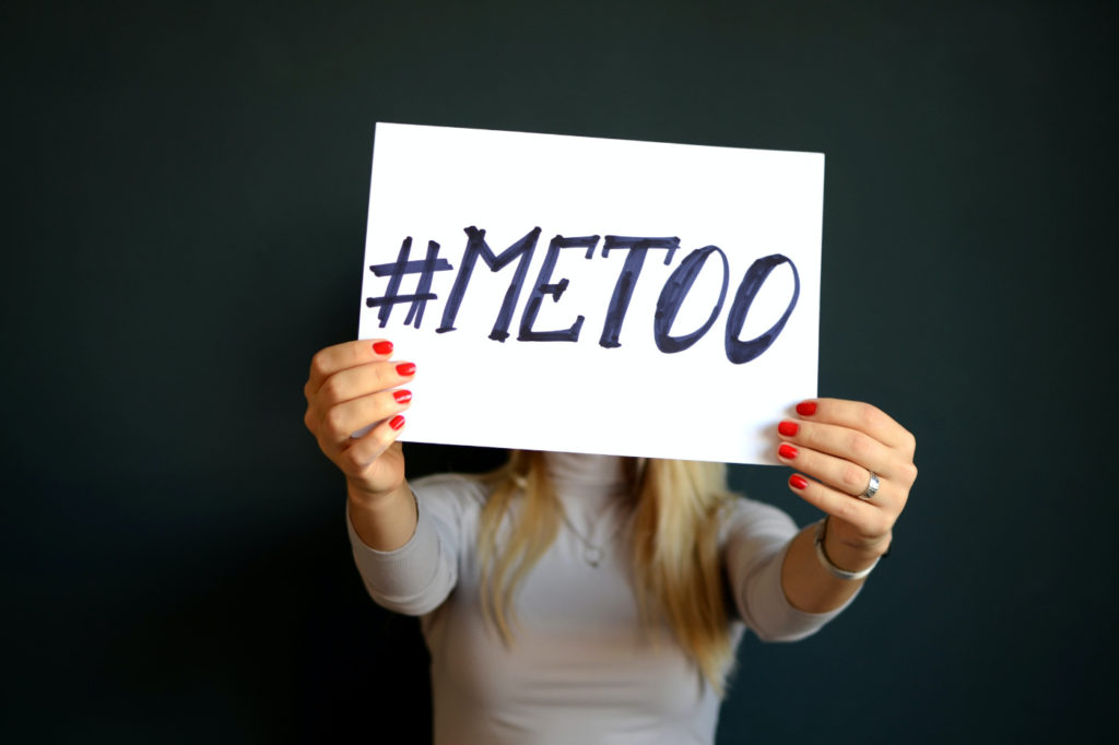 A woman holding a sign with the "#metoo" hashtag.