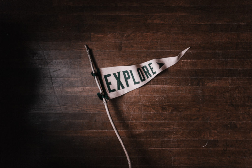 A white flag on a branch with the word "explore" written on it.