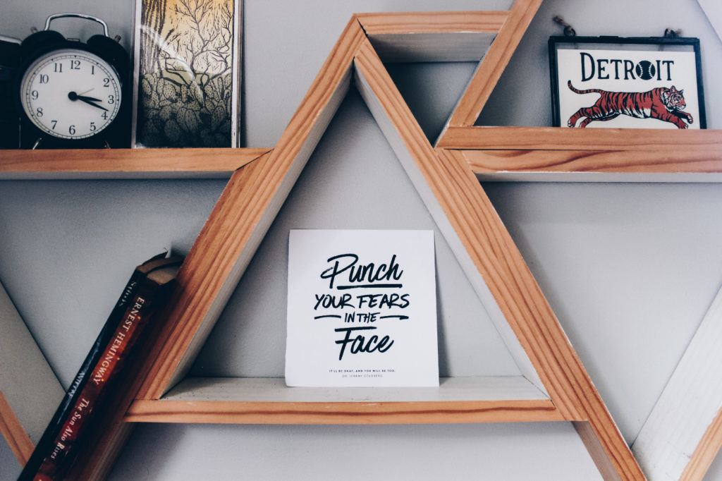 "Punch your fears in the face" poster on a wall shelf.