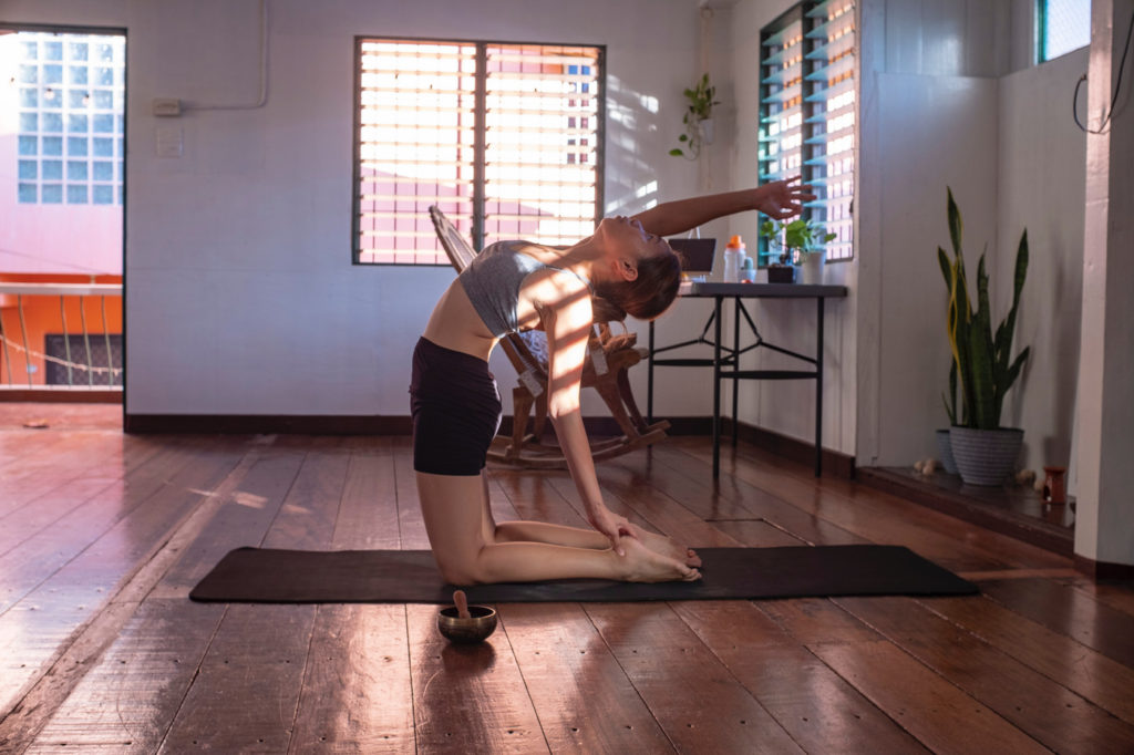 A woman practicing yoga in a home office.