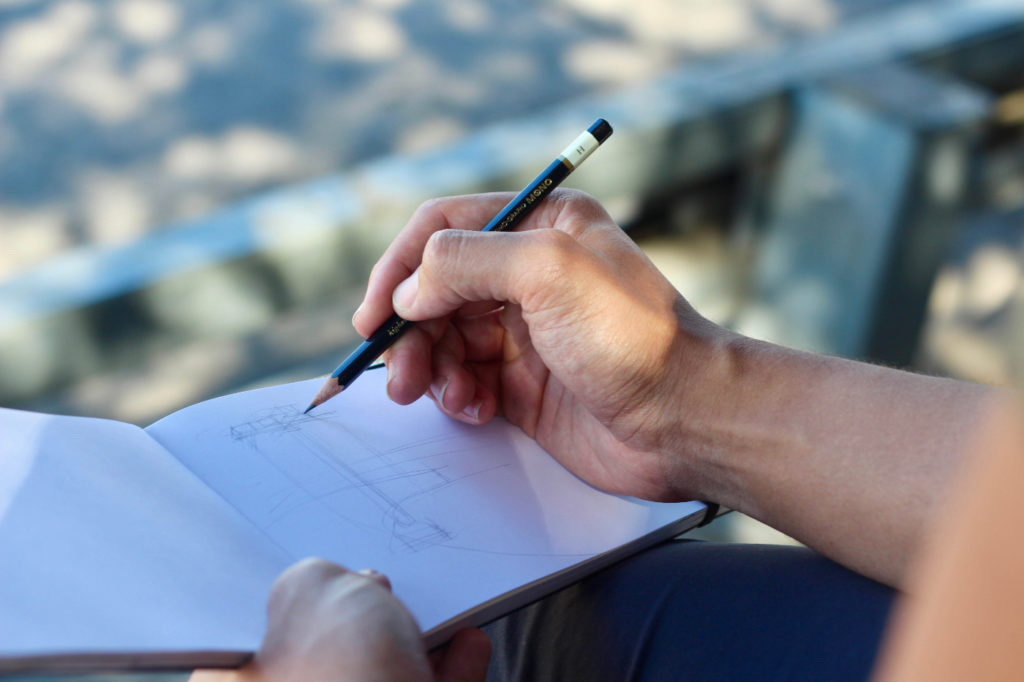 A person sketching in a notebook.