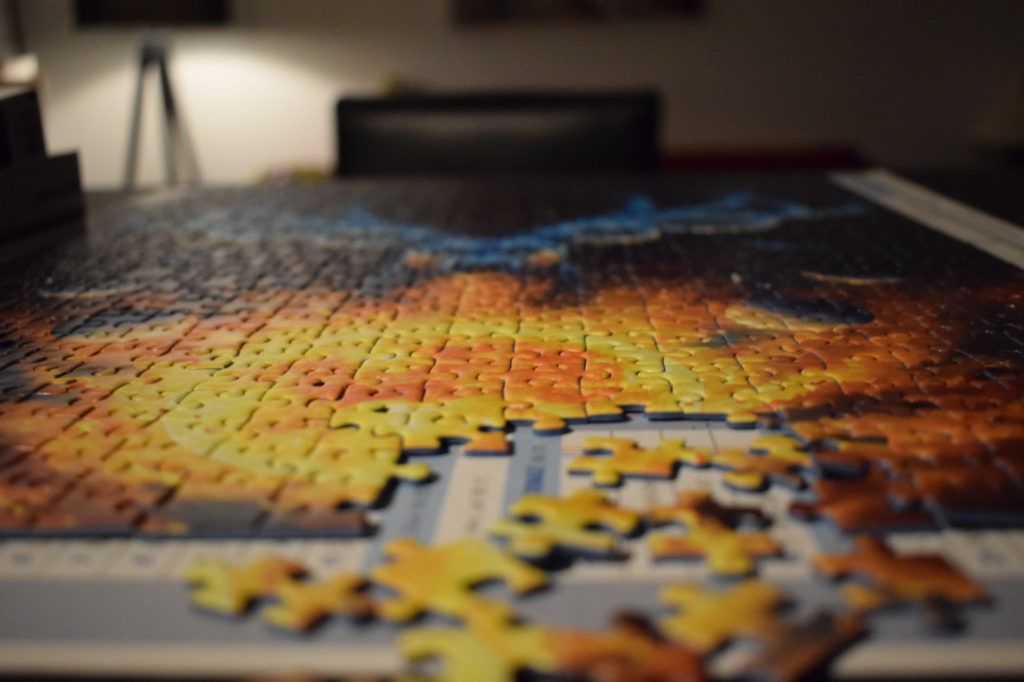 Almost completely assembled jigsaw puzzle on a desk.