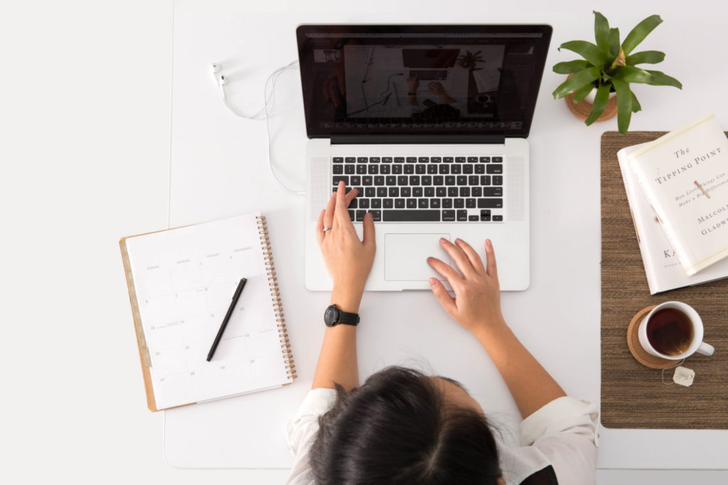 A person working on a laptop at a desk.